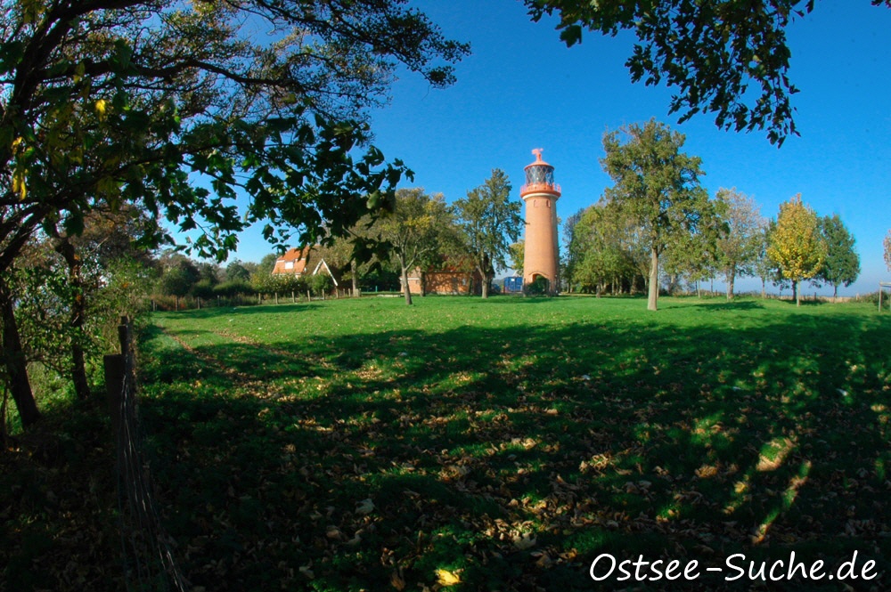 Leuchtturm in Staberhuk auf Fehmarn umgeben von vielen grünen Bäumen