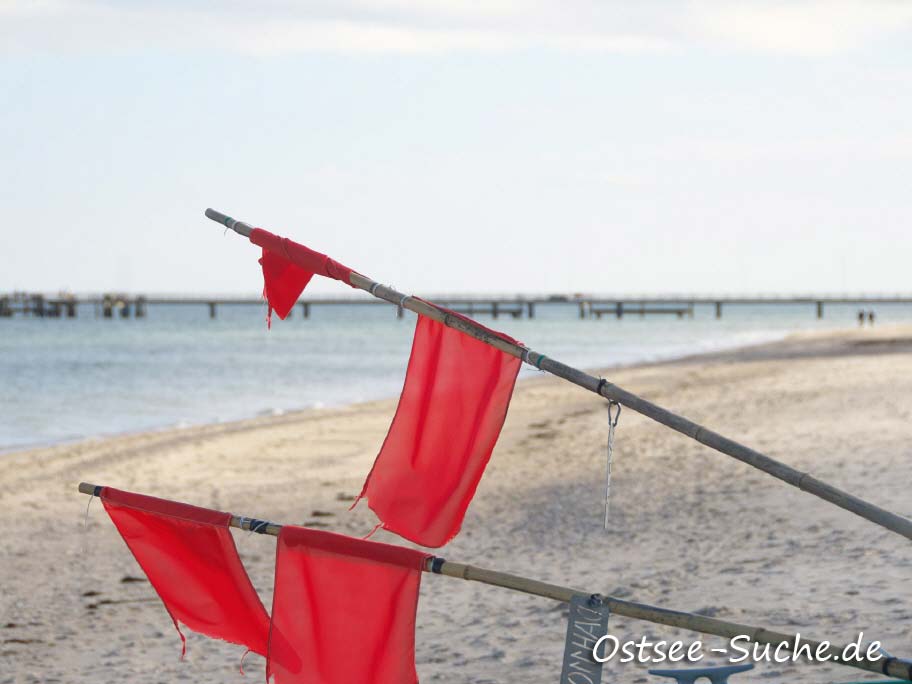 rote Flaggen an den Fischerbojen sind auf dem Ostseestrand von Dahme zu sehen